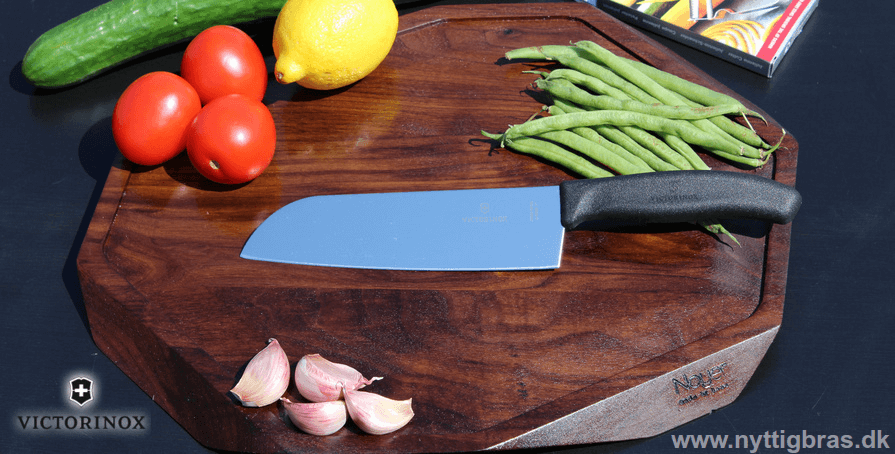 Victorinox Santoku Kokkekniv på Noyer Skærebræt med lækre grøntsager